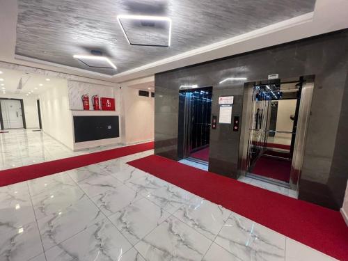 a lobby with a red carpet and an elevator at Modern, City/Industrial Style in Ferizaj