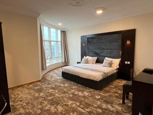 a bedroom with a large bed and a large window at رفد بارك in Abha