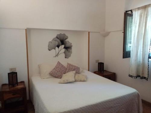 1 dormitorio con 1 cama blanca y 2 almohadas en Bouganville-La Casa Dei Fiori, en Pantelleria
