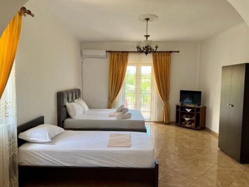ein Schlafzimmer mit 2 Betten und einem TV in der Unterkunft Vila Sidi in Ksamil