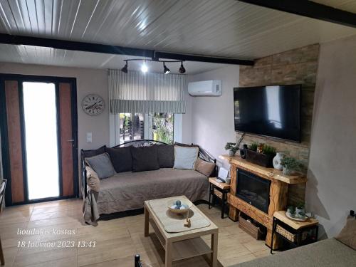 a living room with a couch and a flat screen tv at Zoe garden home in Spáta