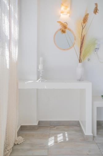 a white table with a mirror and a vase on it at Anemomilos Beach hotel in Agia Anna Naxos