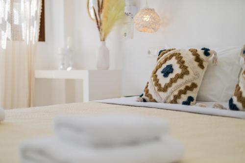 a white bed with two pillows on top of it at Anemomilos Beach hotel in Agia Anna Naxos