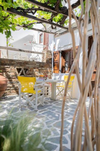 a patio with yellow chairs and a table at Anemomilos Beach hotel in Agia Anna Naxos