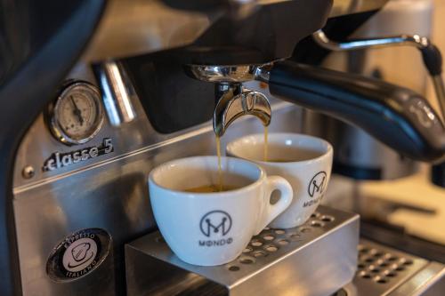 a coffee machine pouring coffee into two coffee cups at Hotel Residence Plaza in Tbilisi City