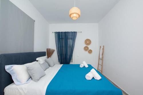 a bedroom with a blue bed with white pillows at Vaqueros in Mýkonos City
