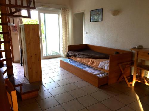 - un salon avec un lit et une grande fenêtre dans l'établissement Hôtel Mer et Forêt, à Saint-Trojan-les-Bains