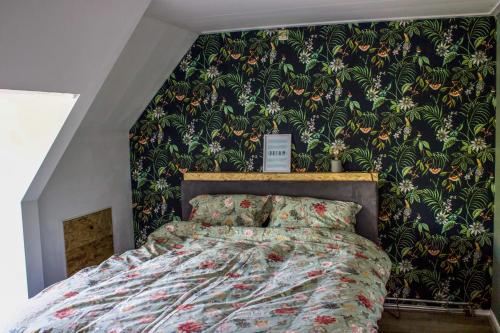 Schlafzimmer mit einem Bett mit einer grünen und orangefarbenen Tapete in der Unterkunft Slapen bij Bartje in Assen