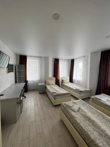 a room with three beds and a desk in it at Hotel Lime in Kyiv