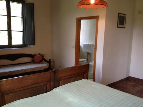 a bedroom with two beds and a window and a bathroom at Palazzo Di Piero in Sarteano