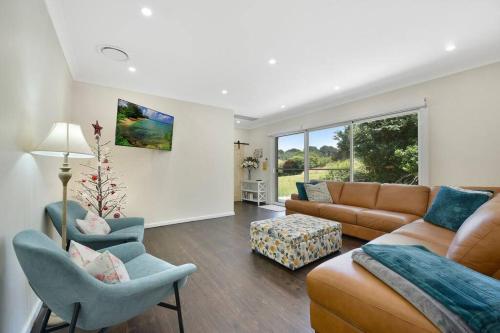 a living room with a couch and chairs and a table at Nuach cottage - Beautiful Family home in Leura in Leura