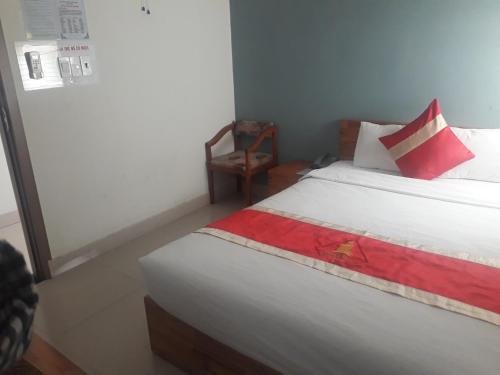 a bedroom with a bed with red and white pillows at Hotel Bảo Quang in Phú Khê (2)