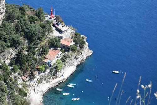 an island with a lighthouse and boats in the water at Apartments Sandra in Brseč