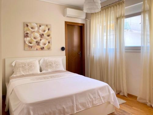 a bedroom with a white bed and a window at East Coast Thessaloniki in Thessaloniki