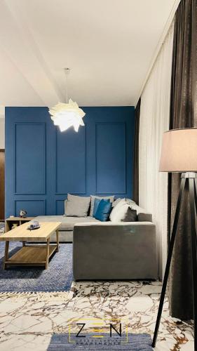 a living room with blue walls and a couch at Zen Apartments Pejë in Peje