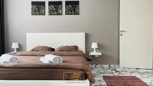 - une chambre avec un grand lit et des serviettes dans l'établissement Zen Apartments Pejë, à Peje