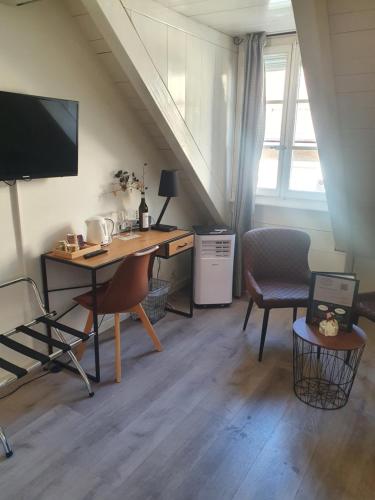 a room with a desk and a computer and a window at L'Hôtel by Hostellerie du Château in Rolle