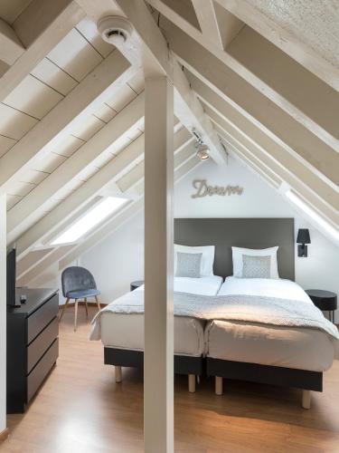 a bedroom with a large bed in a attic at L'Hôtel by Hostellerie du Château in Rolle