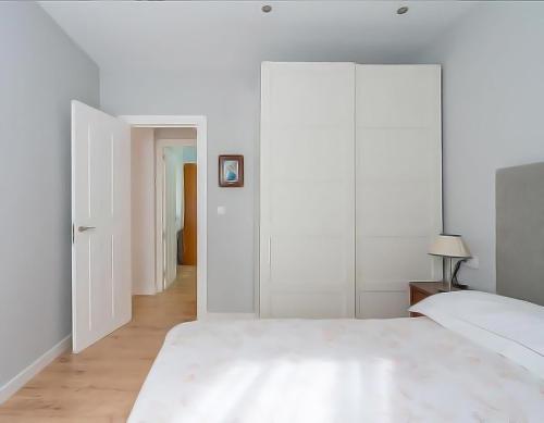 1 dormitorio con paredes blancas y 1 cama grande en COSY Apartment AREETA STATION las Arenas Getxo, en Getxo
