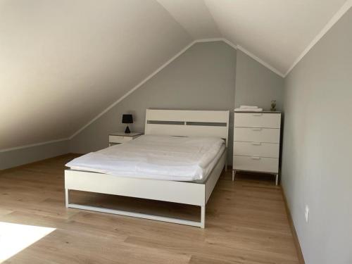 a bedroom with a white bed and a white dresser at Apartament Górska Fantazja in Ustroń