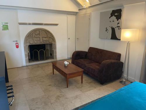 a living room with a couch and a fireplace at L'Hôtel by Hostellerie du Château in Rolle