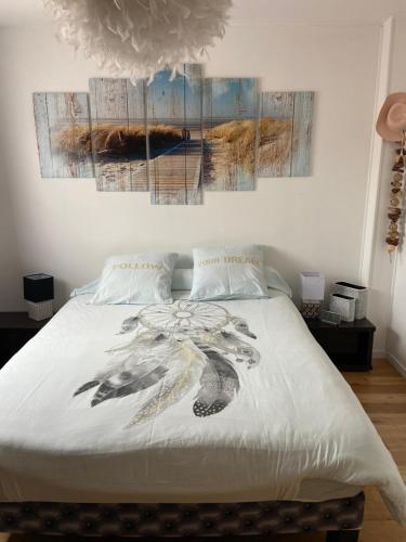 ein Schlafzimmer mit einem Bett mit zwei Gemälden an der Wand in der Unterkunft Chambres dans villa avec piscine in Gleizé