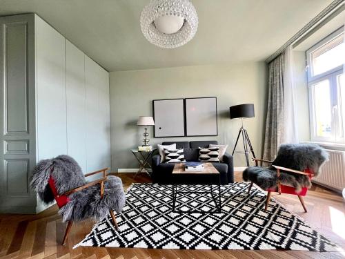 ウィーンにあるNew Luxury Apartment Viennaのリビングルーム(椅子2脚、ソファ付)