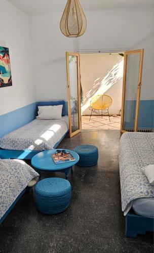 a room with two beds and a table and a mirror at Hotel Villa Soleil in Sidi Kaouki