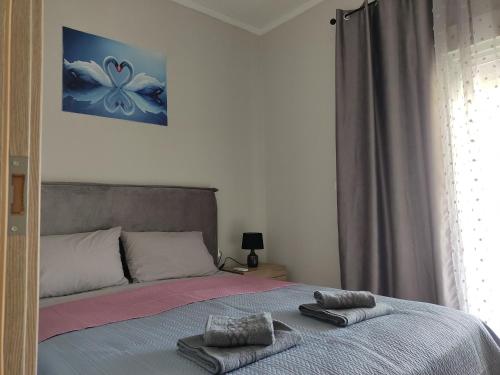 a bedroom with a bed with two towels on it at Elina House and Garden in Nikiti