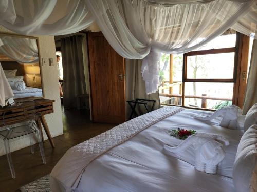 a bedroom with a large white bed with flowers on it at Karongwe - Kuname Safari Lodge in Hoedspruit