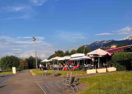 un restaurant avec des tables, des chaises et des parasols dans l'établissement Situé à 100 mètres de la plage duplex de 65 m2, à Évian-les-Bains