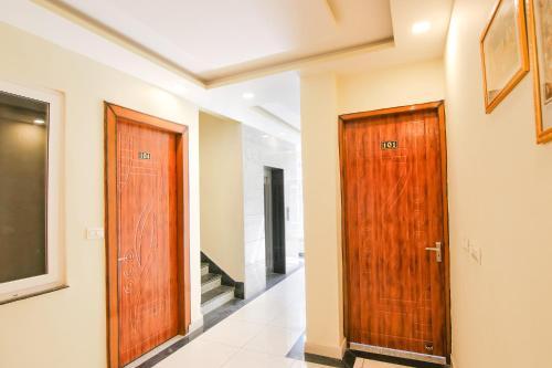 two wooden doors in a hallway with stairs at Hotel Kaanha Residency Inn By Shree Krishna Hospitality in Rishīkesh