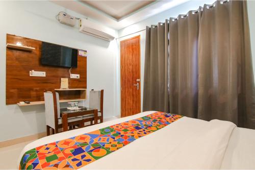 a bedroom with a bed and a desk and a television at Hotel Kaanha Residency Inn By Shree Krishna Hospitality in Rishīkesh