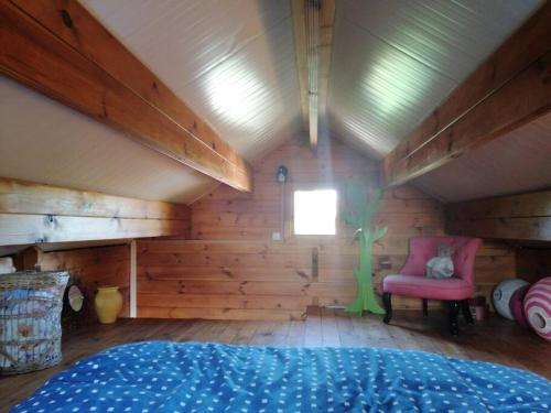 Massay的住宿－Agréable chalet en bois et son extérieur，客房设有床、椅子和窗户。