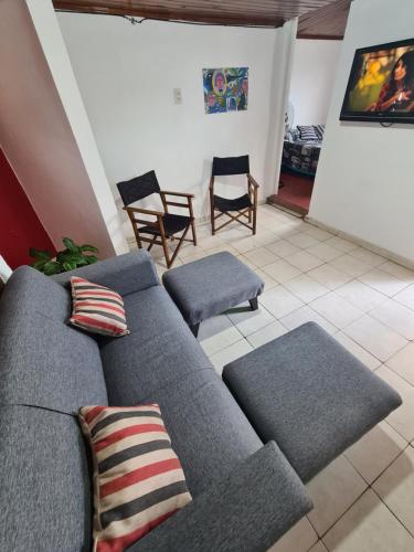 ein Wohnzimmer mit einem grauen Sofa und Stühlen in der Unterkunft Depto confortable para 4 Personas in Posadas