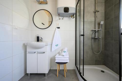 uma casa de banho com um chuveiro, um lavatório e uma banheira em Resort Za Lasem em Jarosławiec