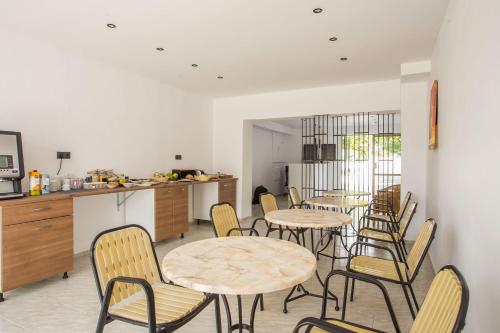 una habitación con mesas y sillas y una cocina en Nikos BnB, en Faliraki