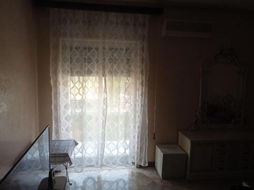 Zimmer mit einer Tür mit einem Fenster und Hilfen in der Unterkunft White Room, Stanza Matrimoniale in zona centrale in Syrakus