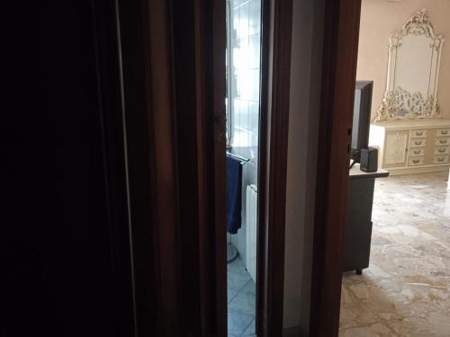 eine Tür zu einem Zimmer mit einem TV und einem Zimmer in der Unterkunft White Room, Stanza Matrimoniale in zona centrale in Syrakus