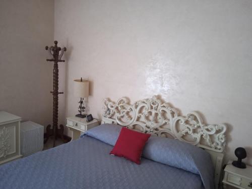 ein Schlafzimmer mit einem Bett mit einem roten Kissen darauf in der Unterkunft White Room, Stanza Matrimoniale in zona centrale in Syrakus