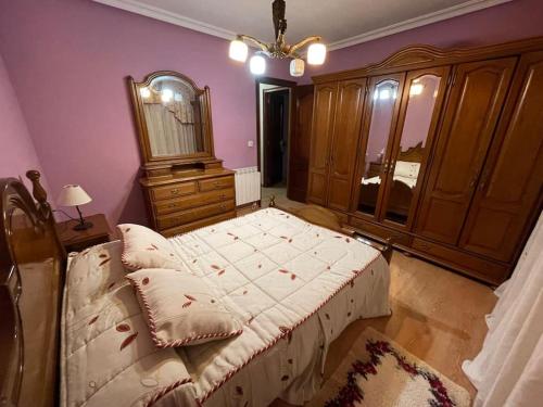 1 dormitorio con 1 cama grande y vestidor en Piso acogedor, en Soto del Barco