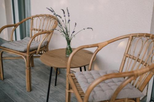 a table and two chairs and a vase with flowers at Ferienhaus in Široki Brijeg