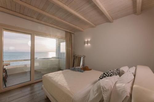 a bedroom with a bed and a view of the ocean at Apartments enosis, Poseidon in Agia Anna Naxos