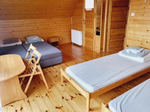 Habitación con 2 camas y una silla. en Wczasowa 54, en Węgorzewo