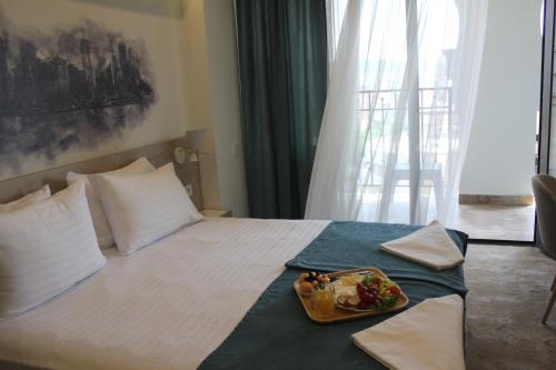 a hotel room with a bed with a tray of food on it at Rooftop Apart-Hotel in Yerevan