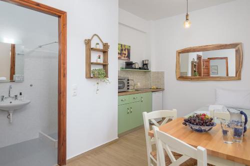 a kitchen with a table with a bowl of fruit on it at Lemon Tree Apartments Samos in Votsalákia
