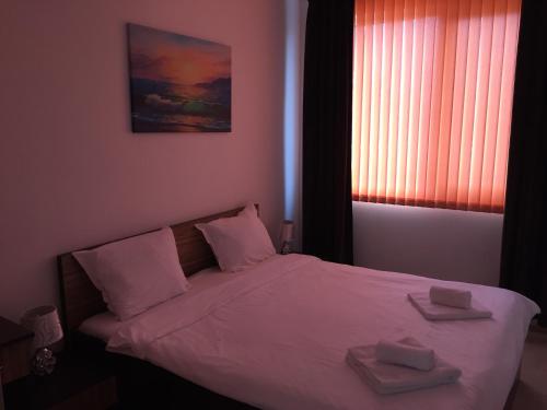 a bedroom with a bed with two towels on it at Тристаен апартамент с Панорама море в к-с Бей Вю Царево in Tsarevo