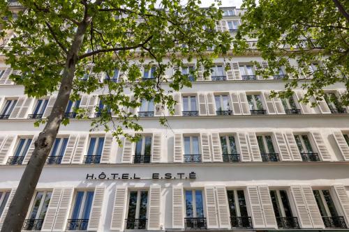 a white building with a hotel exit sign on it at Hôtel Esté in Paris