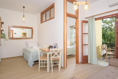 a living room with a table and a bedroom at Lemon Tree Apartments Samos in Votsalákia