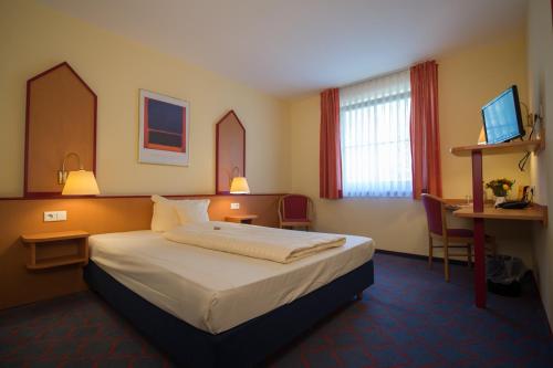 a hotel room with a bed and a desk at Montana Hotel Senden in Senden